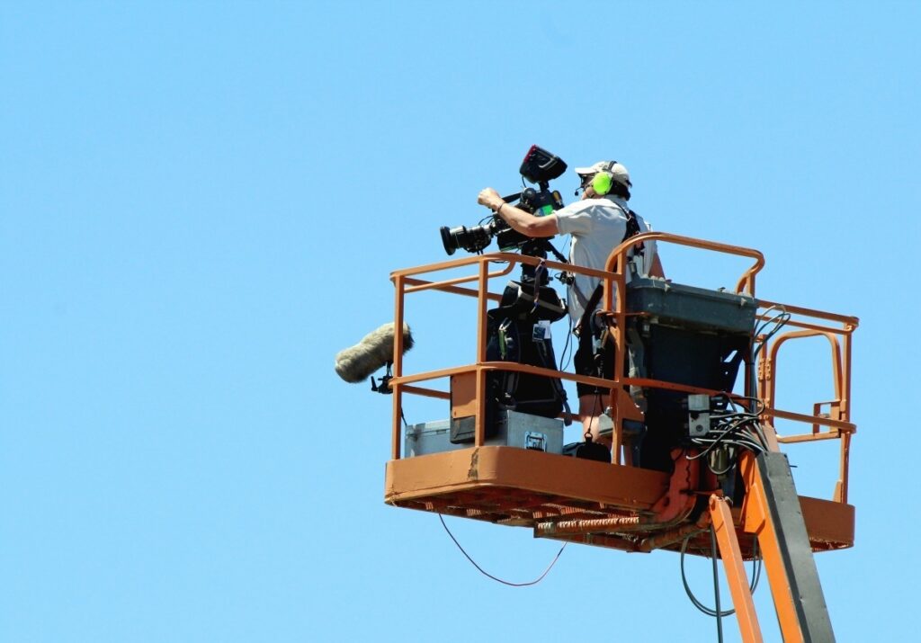 Camera crew on lift illustrating production insurance need
